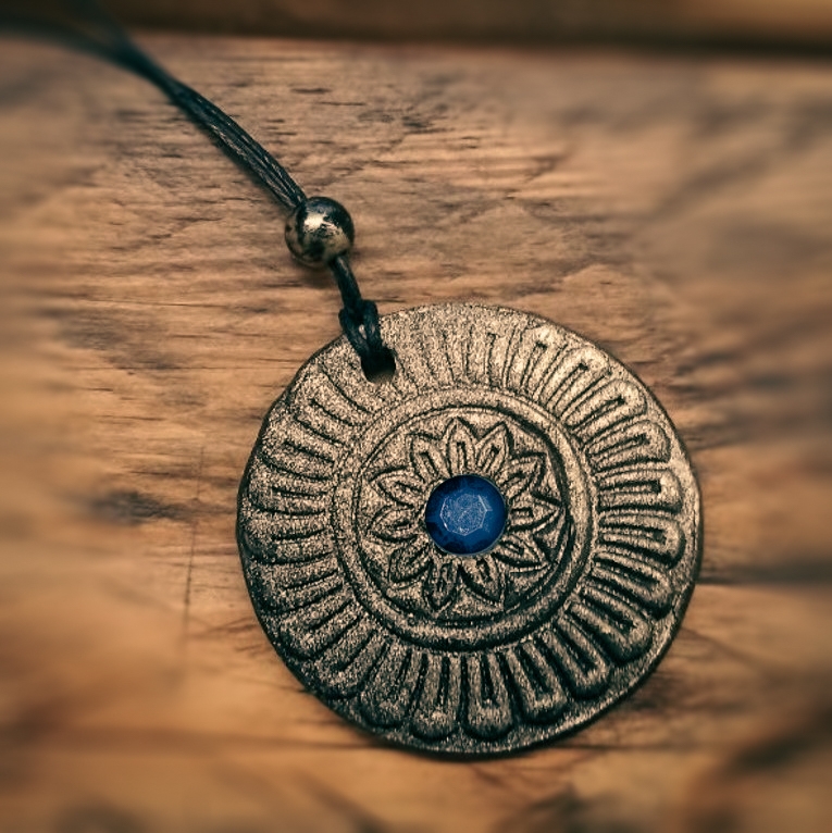 Amulett an Lederband auf Holzhintergrund