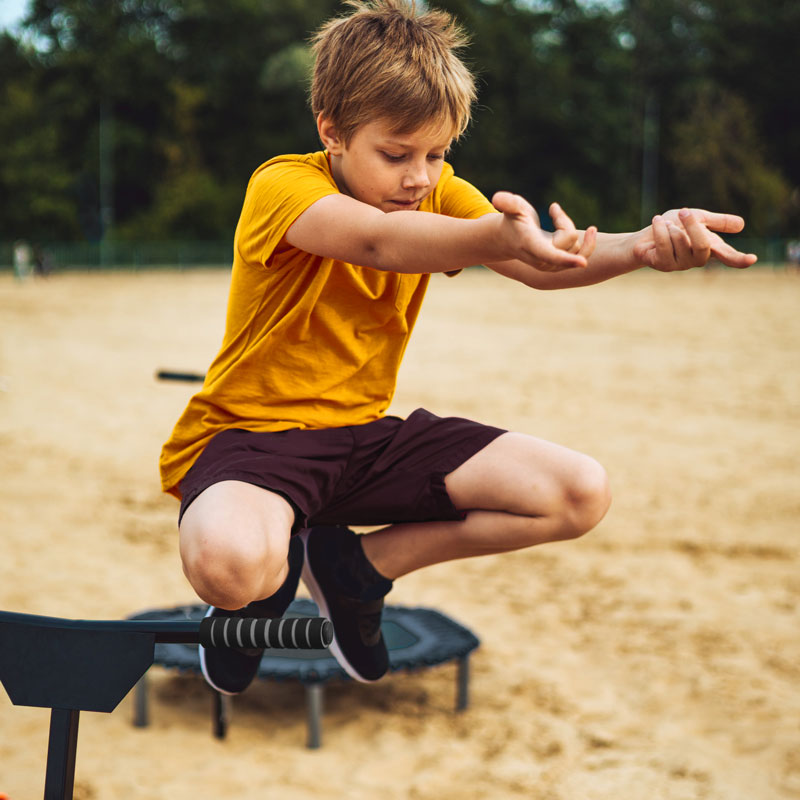 Junge auf Campingplatz Spieleplatz springt Trampolin